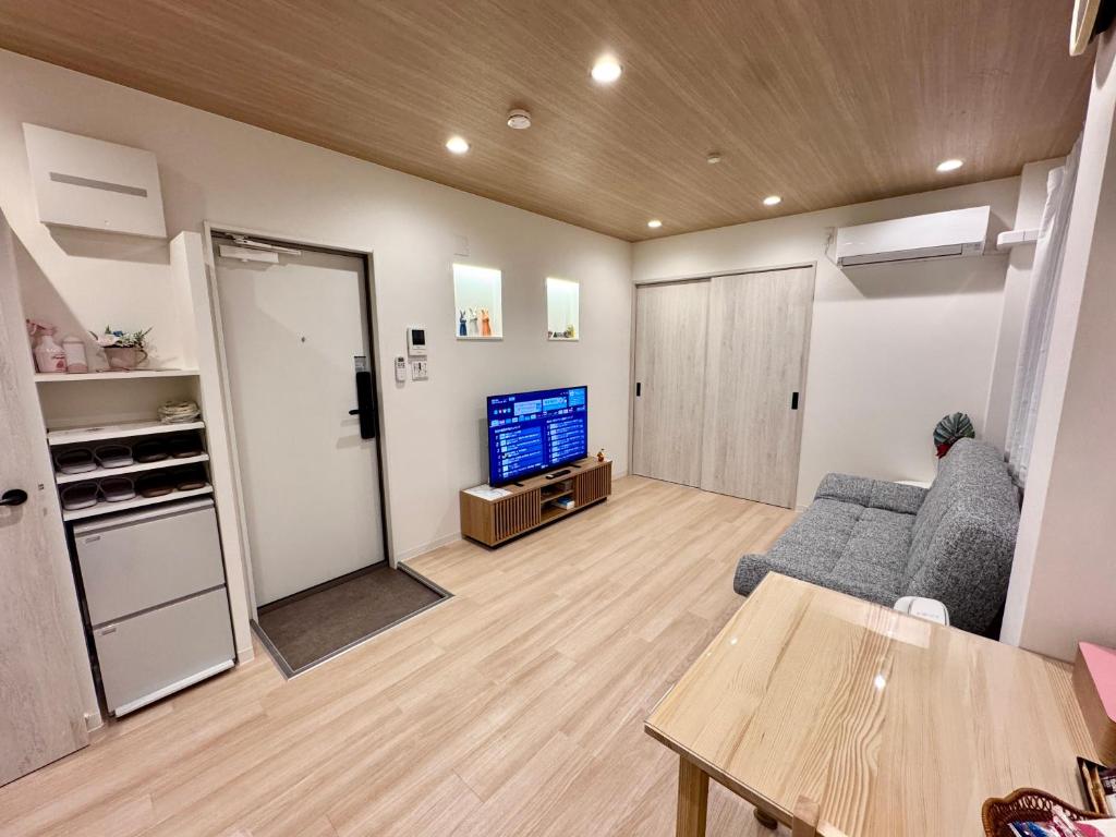 a living room with a couch and a tv at Private Room near Iriya in Tokyo