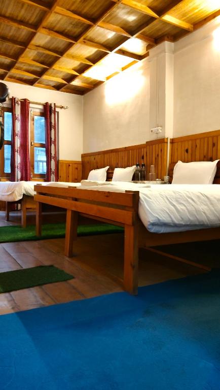 a large room with two beds and a table at Jagnath in Jageshwar