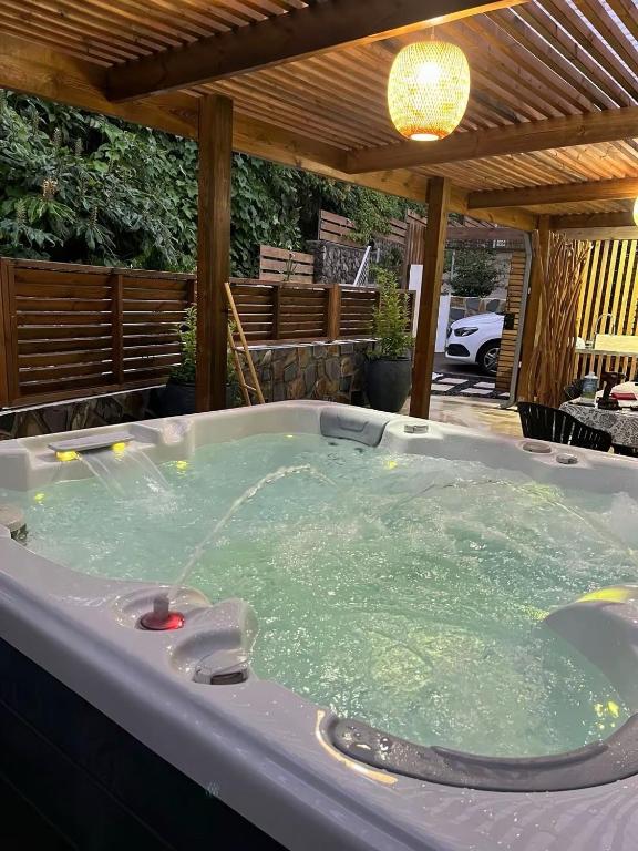 a jacuzzi tub sitting under a pergola at Les panoramiks des Makes in Saint-Louis