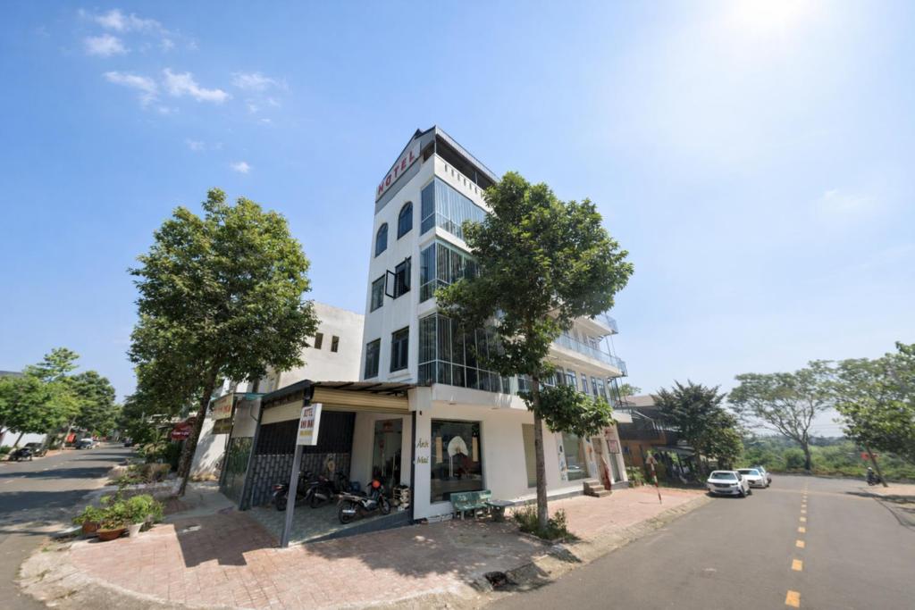 a tall white building on the side of a street at Ánh Mai Hotel in Bảo Lộc