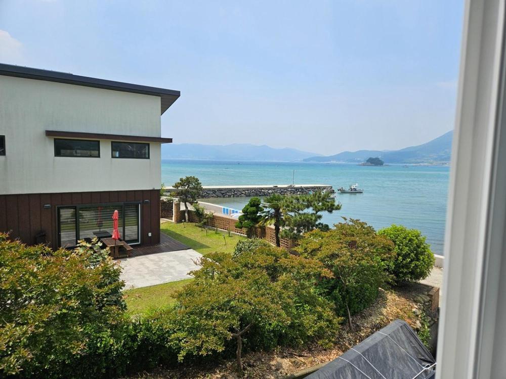 a view of a house and the ocean at Namhae Soljeong Pension in Namhae