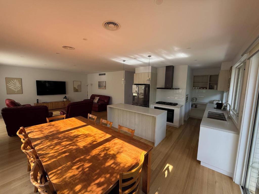 a kitchen and living room with a wooden table in a room at Cowes Central Beach Villa II in Cowes