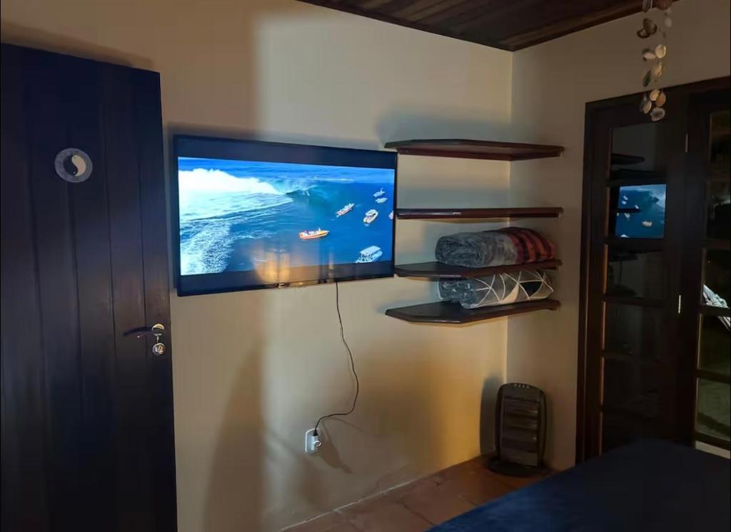 a flat screen tv hanging on a wall at Lar Zen in Garopaba