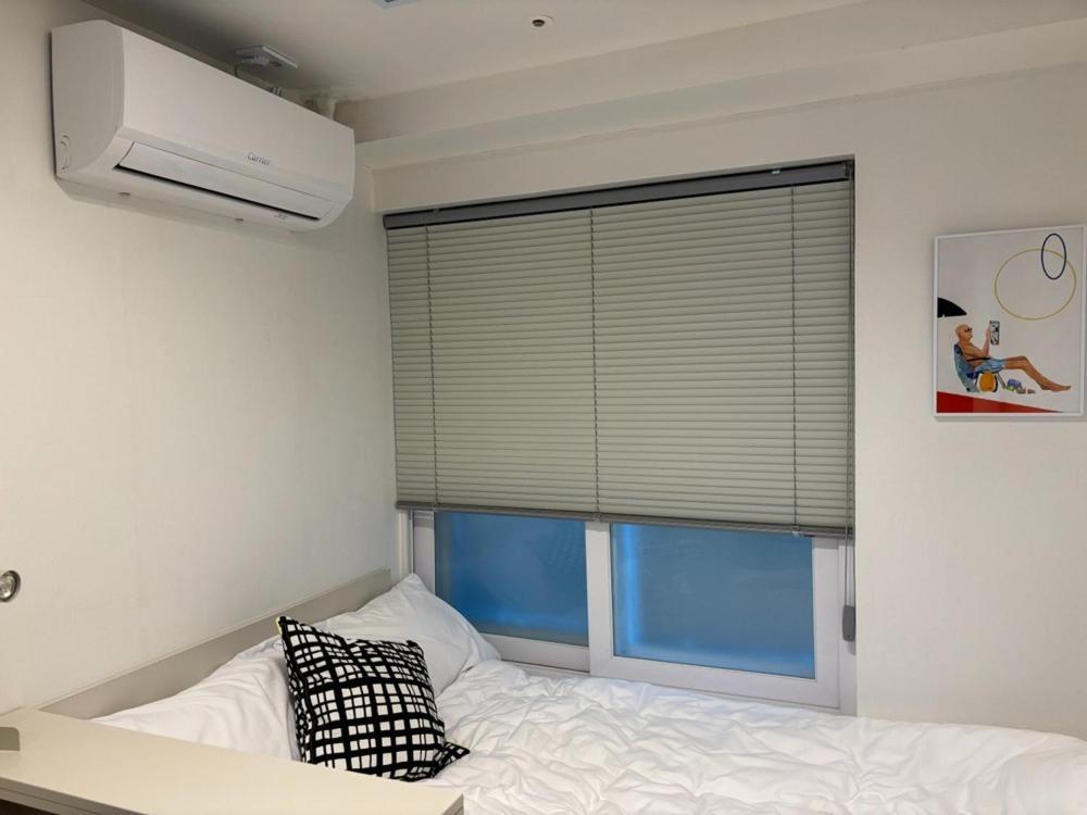 a bedroom with a bed and a window with blinds at Seoul On Stay in Seoul
