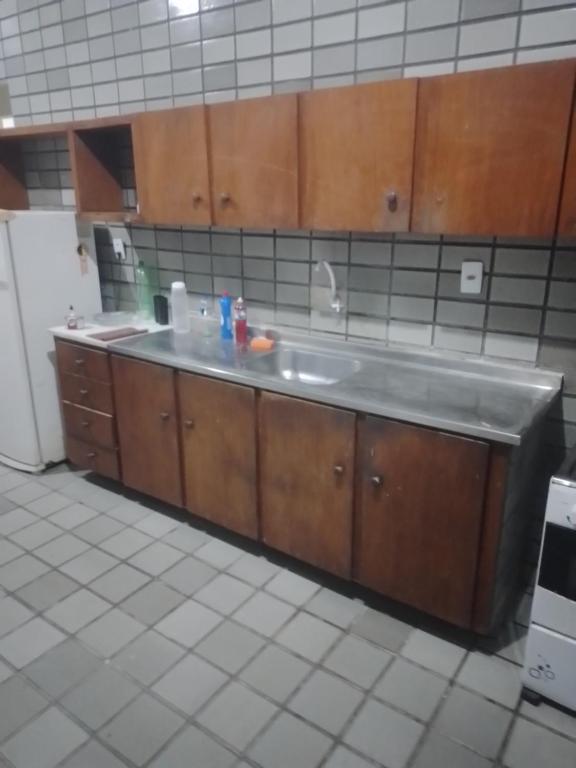 a kitchen with a sink and a refrigerator at Melos hospedagem jp in João Pessoa