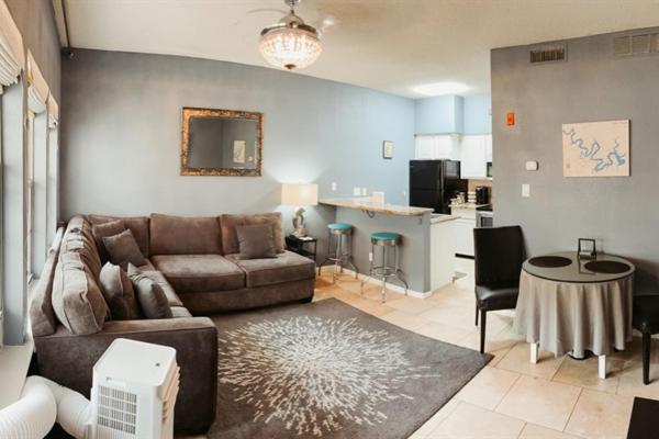 a living room with a couch and a table and a kitchen at Stylish Island Villa on Lake Travis in Lago Vista