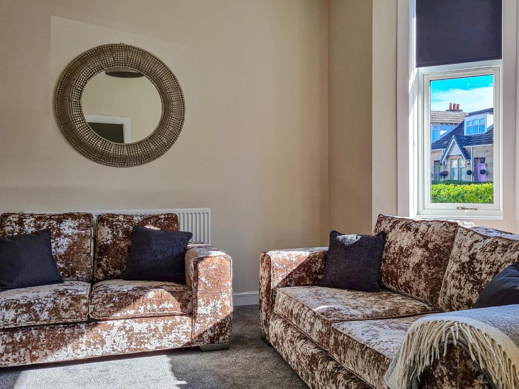 a living room with two couches and a mirror at Kirklea in Wishaw