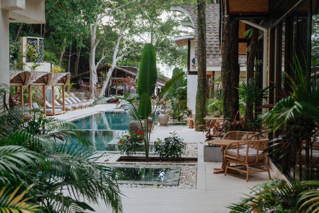 a resort with a pool and tables and chairs at SeaTara Resort in Ko Phangan