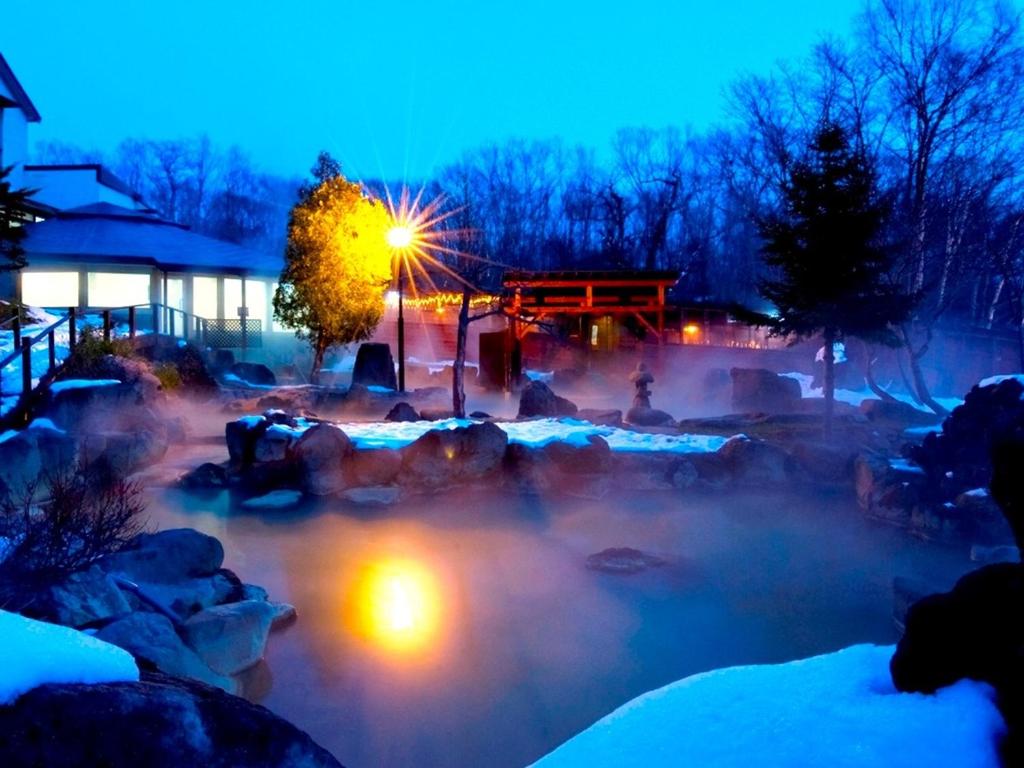 a hot tub with snow on the ground and lights at Niseko Grand Hotel in Niseko