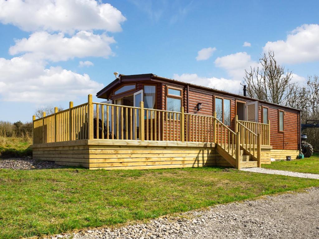 a cabin with a large deck on the grass at Owl Lodge - Uk49144 in Hartshorne