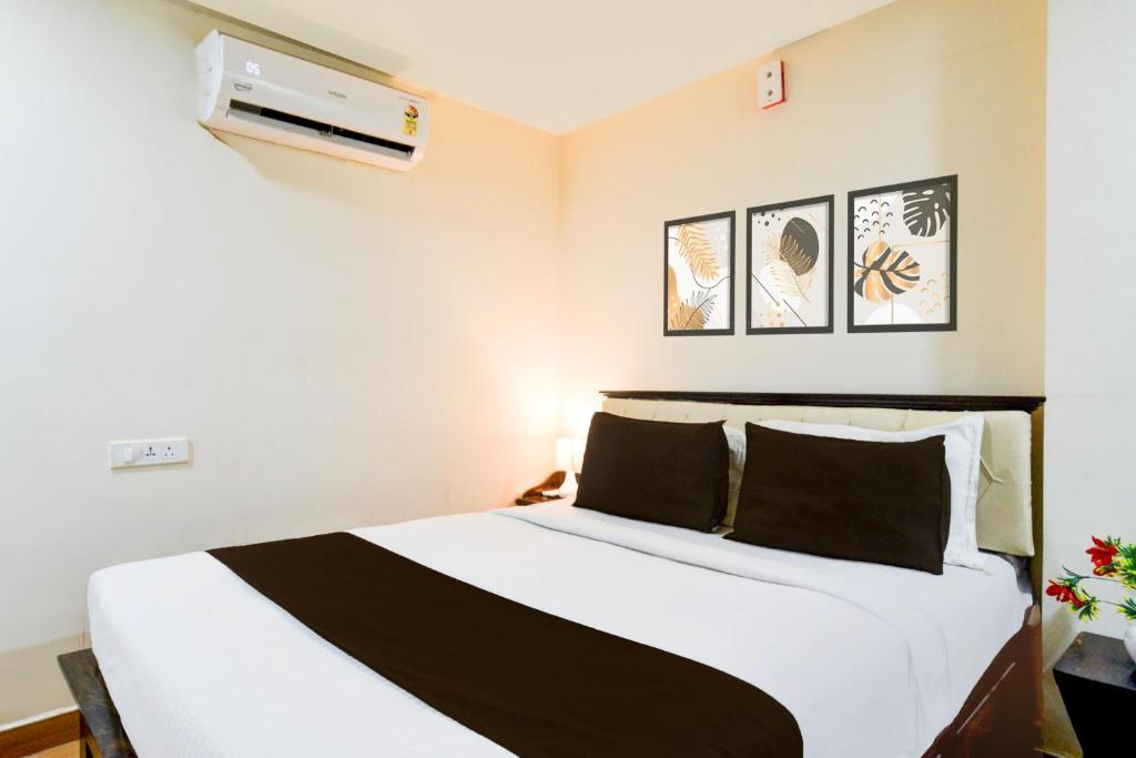a bedroom with a large white bed with black pillows at Townhouse Gachibowli Near Gopichand Academy in Hyderabad