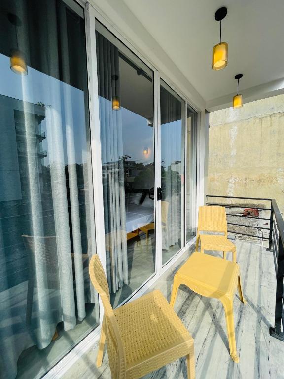 a balcony with two chairs and a table at Yehara Apartments in Weligama