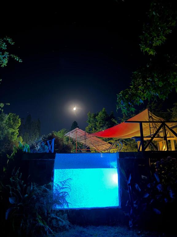 a swimming pool at night with a tent and umbrella at Termas del Vino 3 in Palmilla Abajo