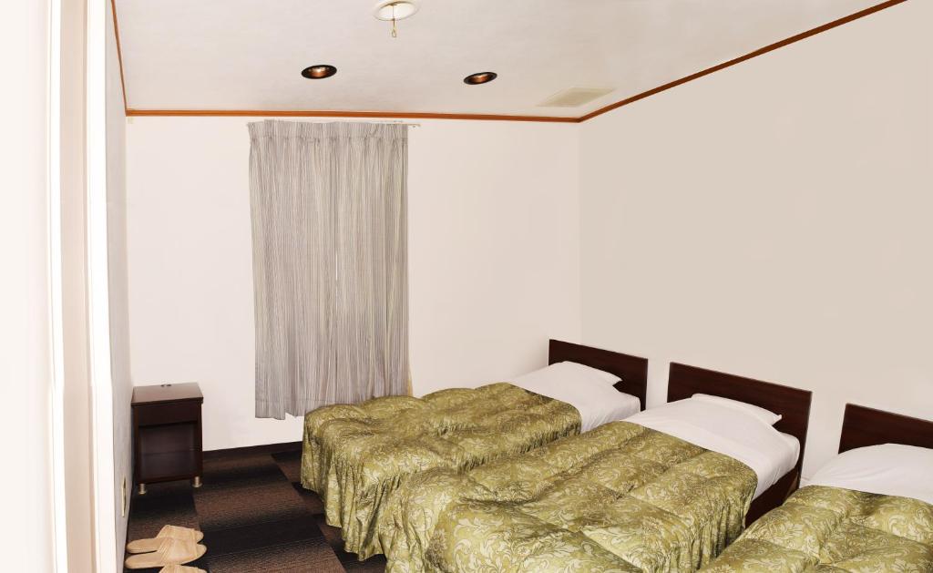 Postel nebo postele na pokoji v ubytování Sakura Hotel Oami