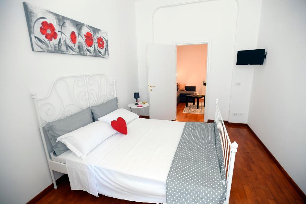 a bedroom with a white bed with a red heart on it at Big House Colosseum in Rome