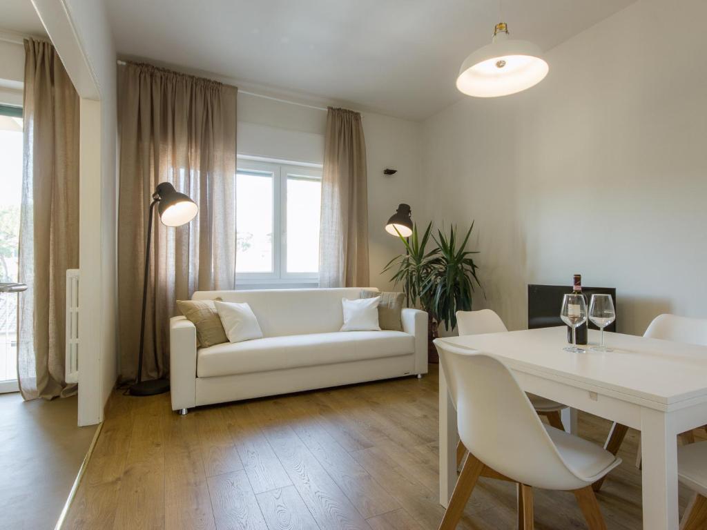フィレンツェにあるGelsomino Apartmentのリビングルーム(白いソファ、テーブル付)