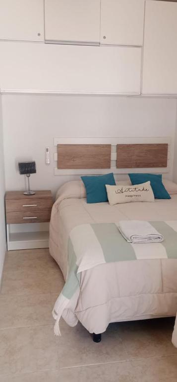 a bedroom with a large white bed with blue pillows at Atenea in Chivilcoy