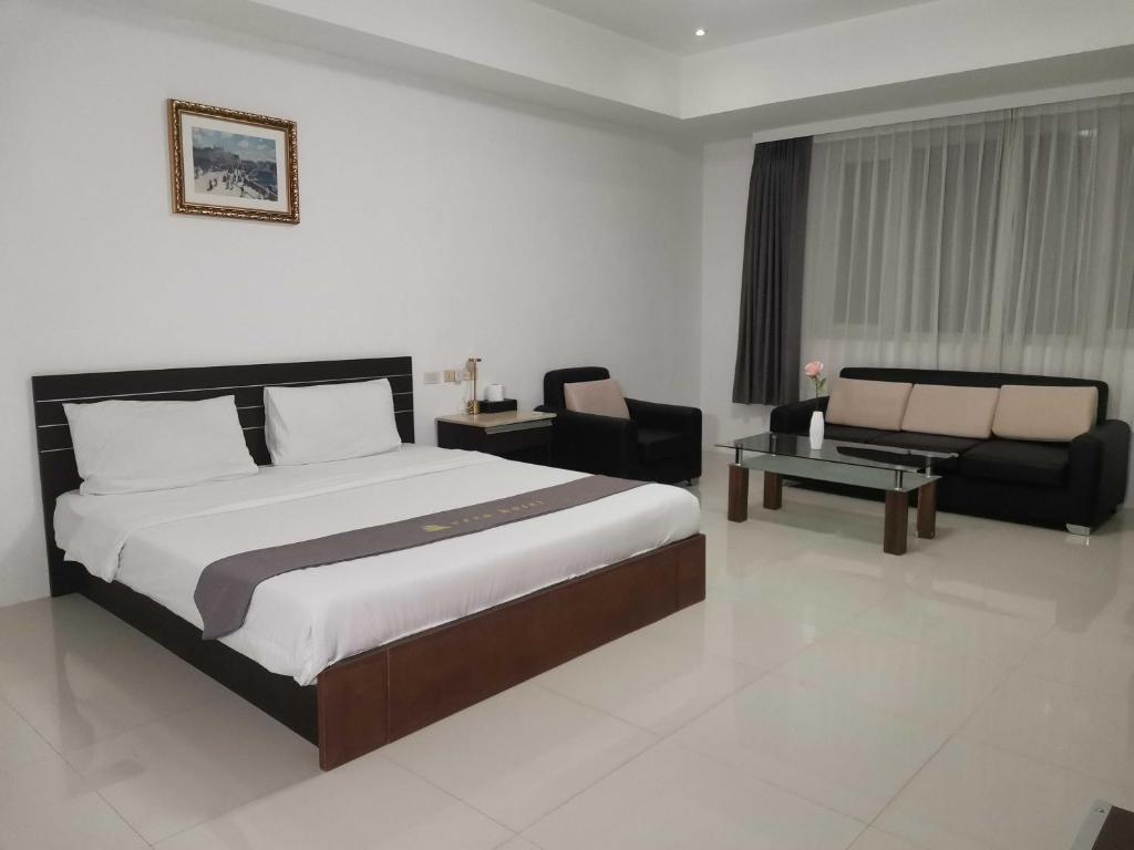 a bedroom with a bed and a couch and a chair at Townhouse Oak Vera Hotel Near Clark International Airport in Angeles