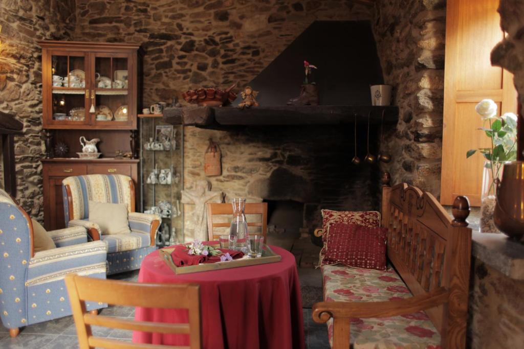 salon ze stołem i kominkiem w obiekcie Casa Rural Penaquente w mieście Santa Marta de Ortigueira