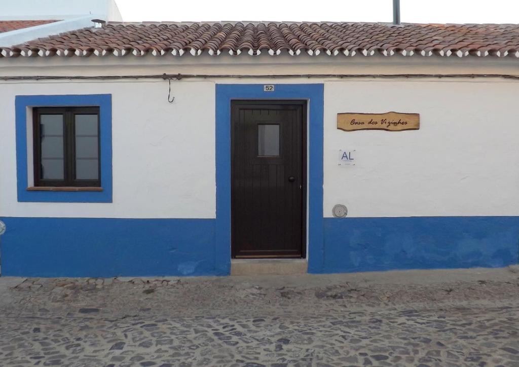un edificio azul y blanco con una puerta y una señal en Casa dos Vizinhos - Casas de Taipa, en São Pedro do Corval