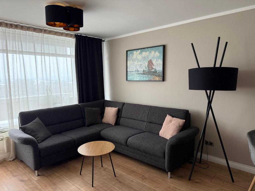 a living room with a couch and a table at FeWo am Hansa Park in Sierksdorf