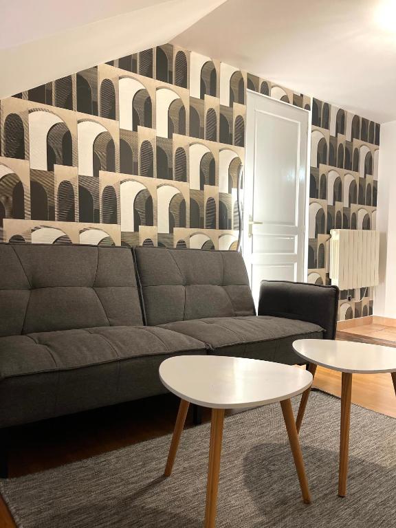 a living room with a couch and two tables at Troisieme du nom in Nevers