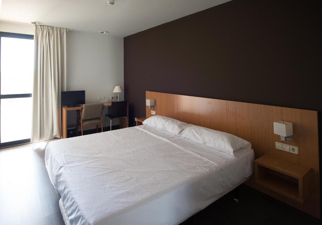 馬德里的住宿－Hostal Mediterranea，一间卧室配有一张大床和一张桌子及椅子