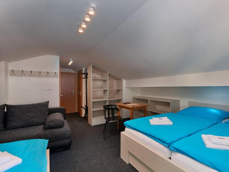 um quarto com uma cama azul e um sofá em Haus Vinzenz em Obertauern