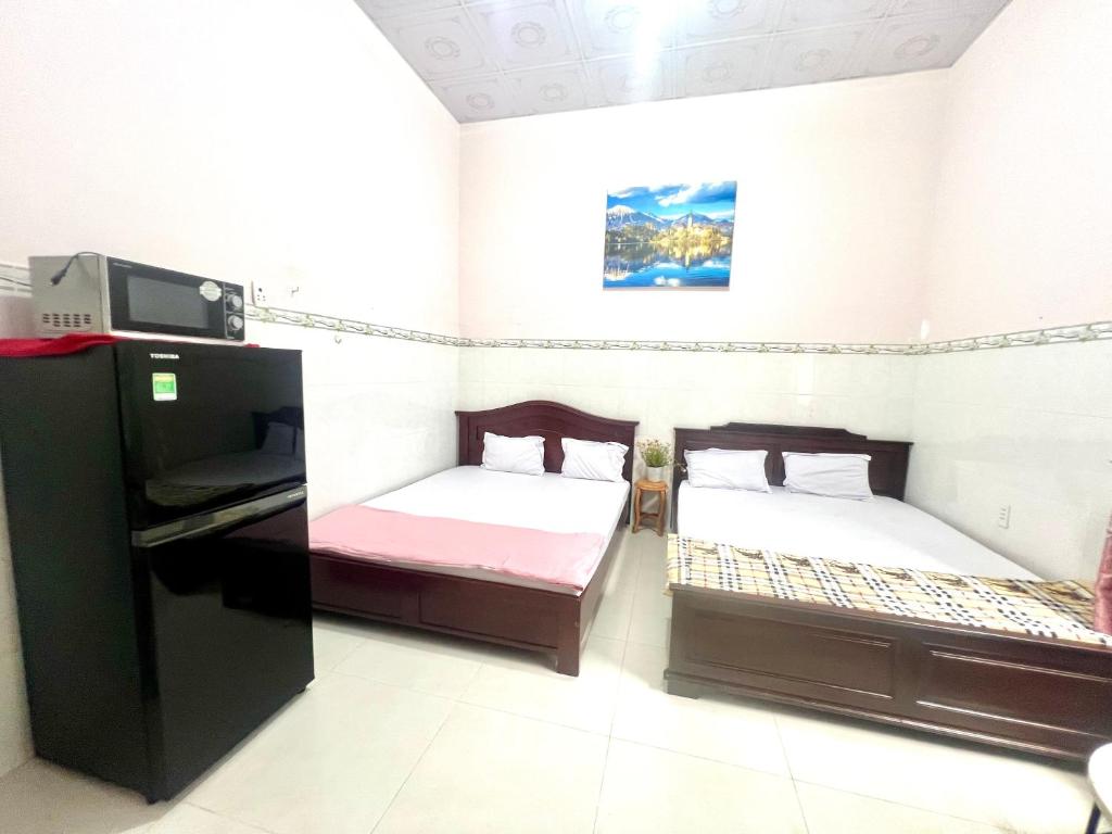 a room with two beds and a tv in it at LaMera Hotel Homestay in Ben Tre