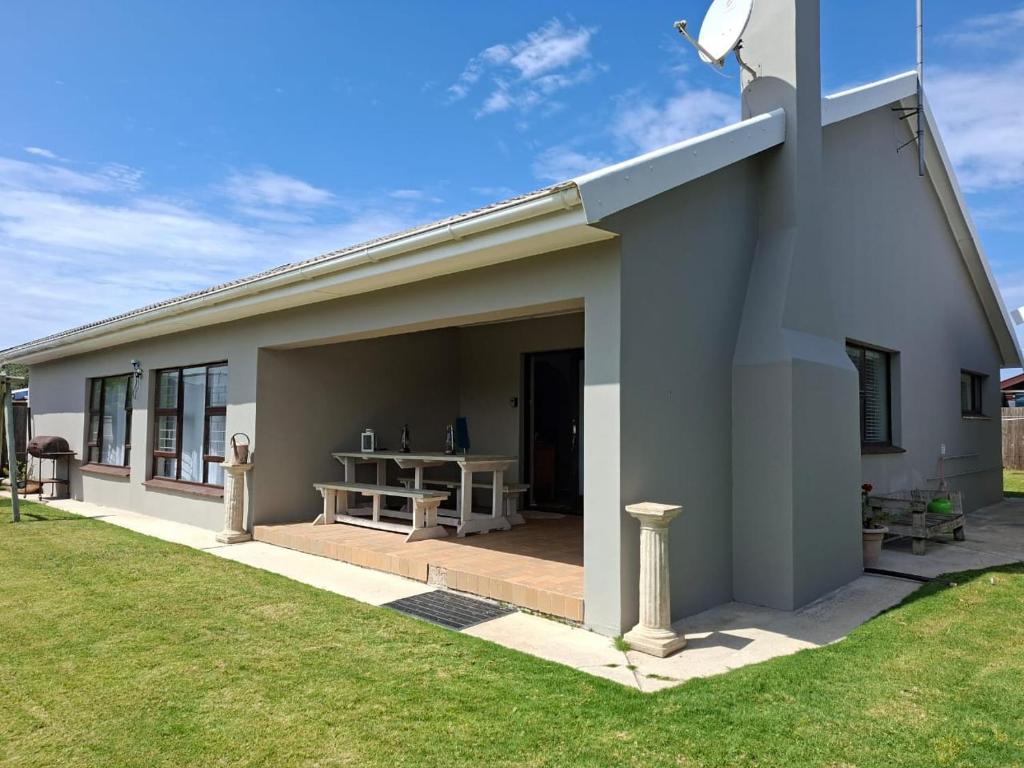 a small house with a patio and a grass yard at Omidraai Opihoek in Boknes