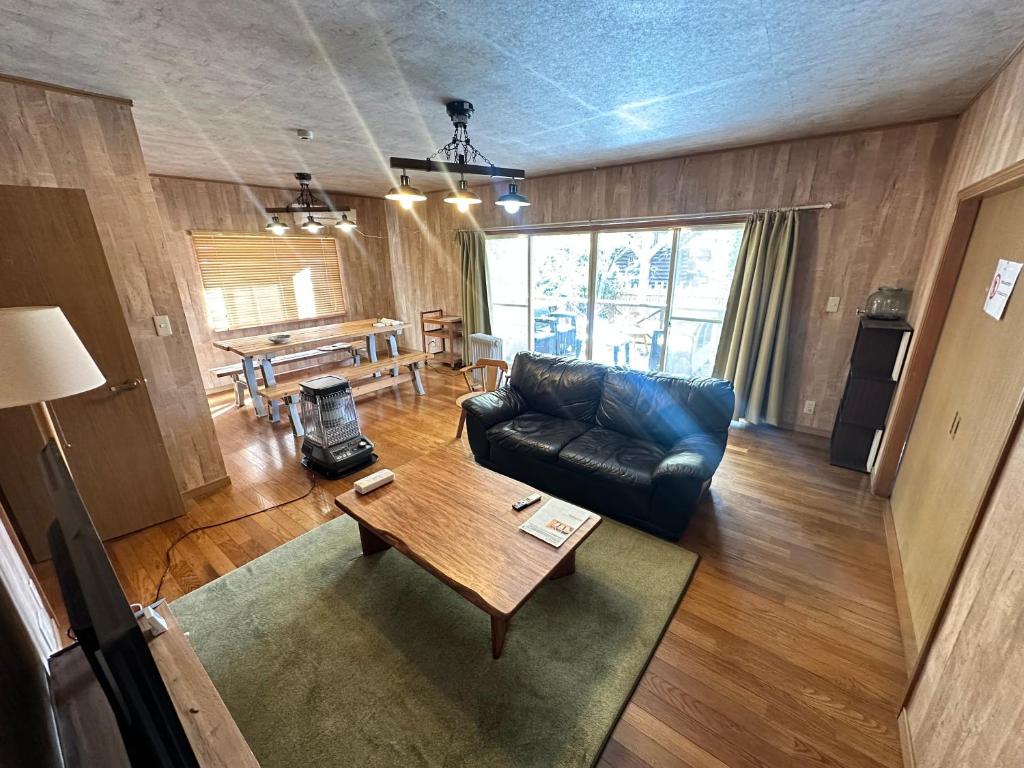 a living room with a couch and a table at 一棟丸ごと貸別荘あそべるごでぃふーぞ in Takamori