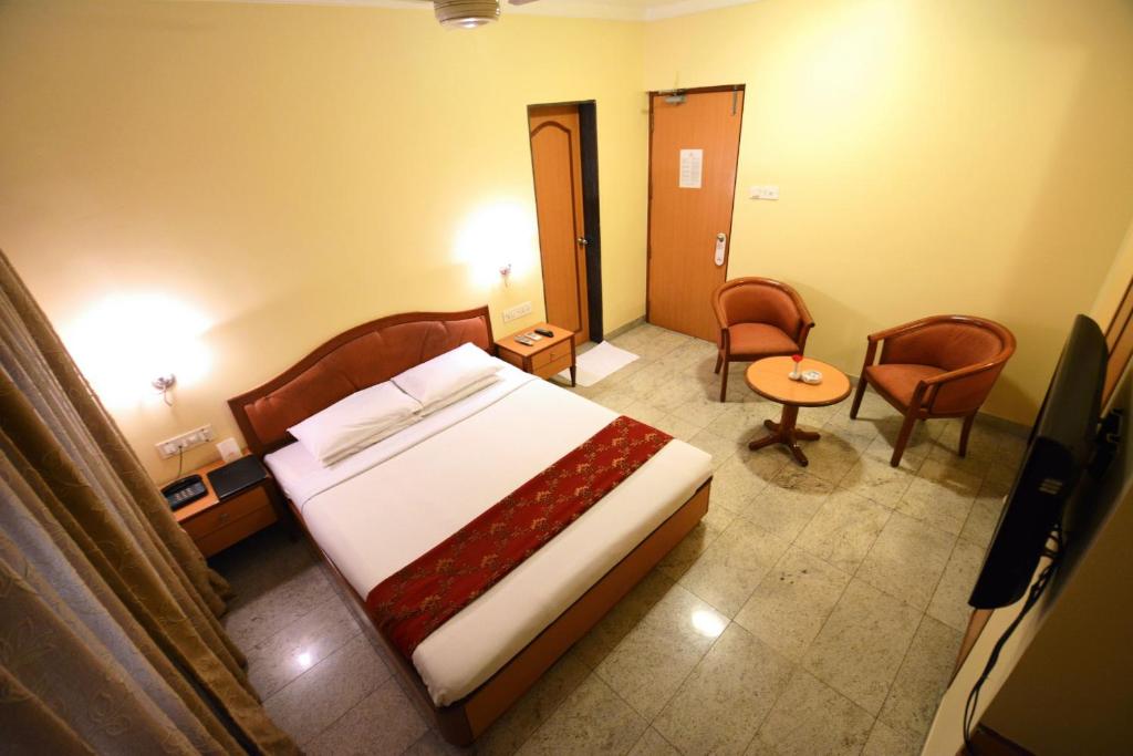 Postel nebo postele na pokoji v ubytování The Samrat Hotel near Pune Railway Station