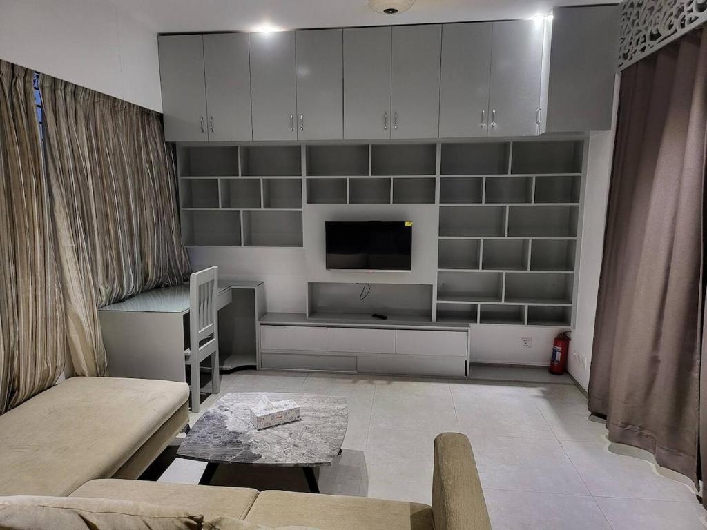 un soggiorno con un divano e una TV di 1BR Studio with Rooftop Access a Dhaka