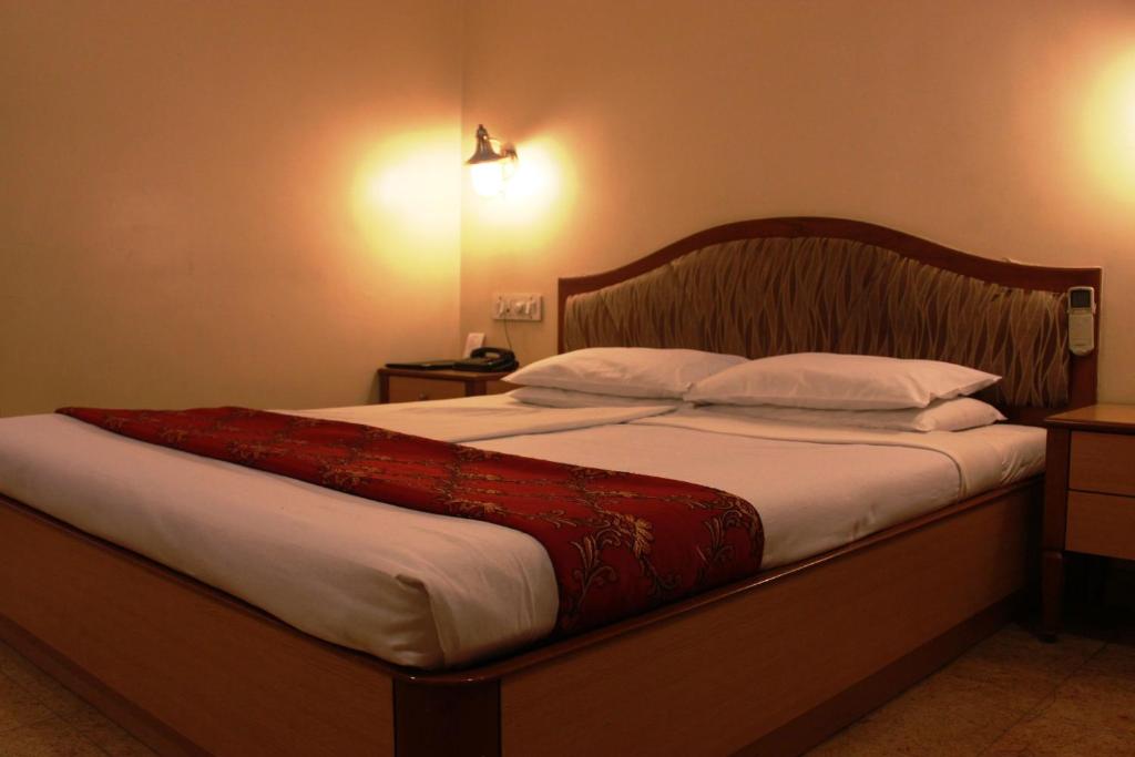 Postel nebo postele na pokoji v ubytování The Samrat Hotel near Pune Railway Station