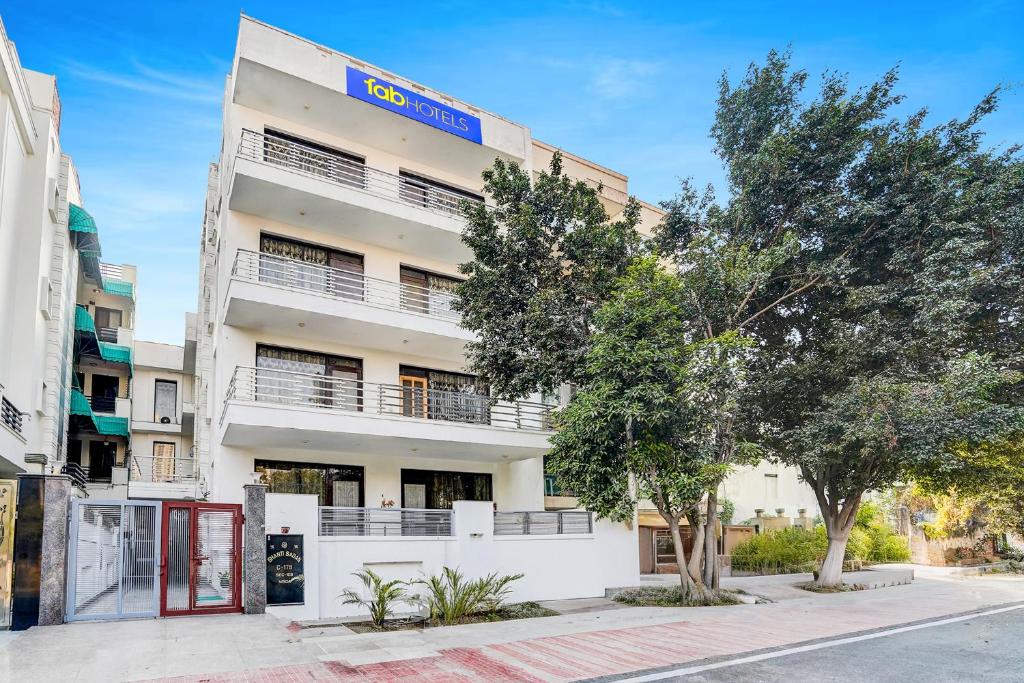 a white building with trees in front of it at FabHotel Sarala Residency in Noida