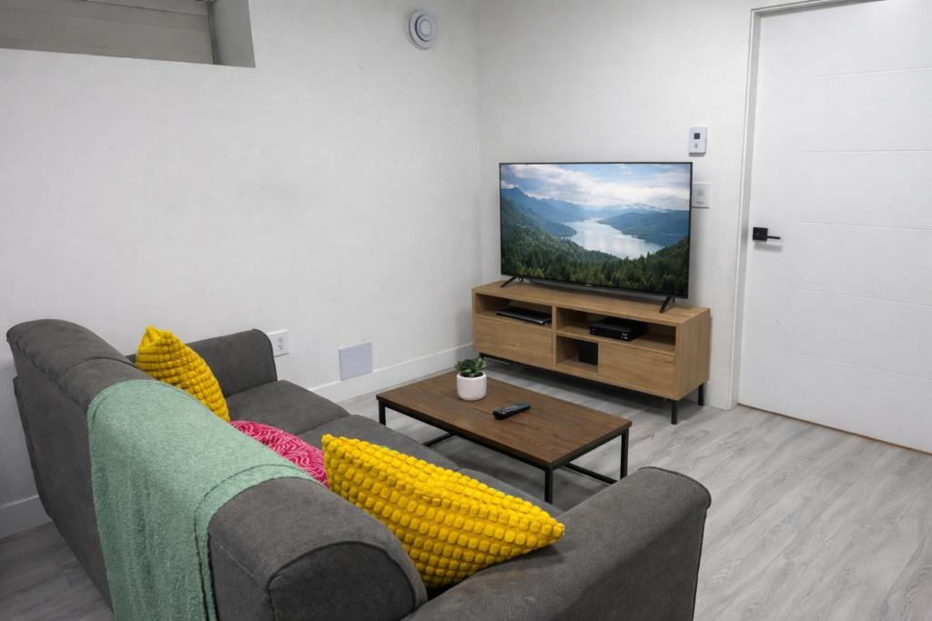 a living room with a couch and a flat screen tv at Comfort 2 BR Vancouver! in Vancouver