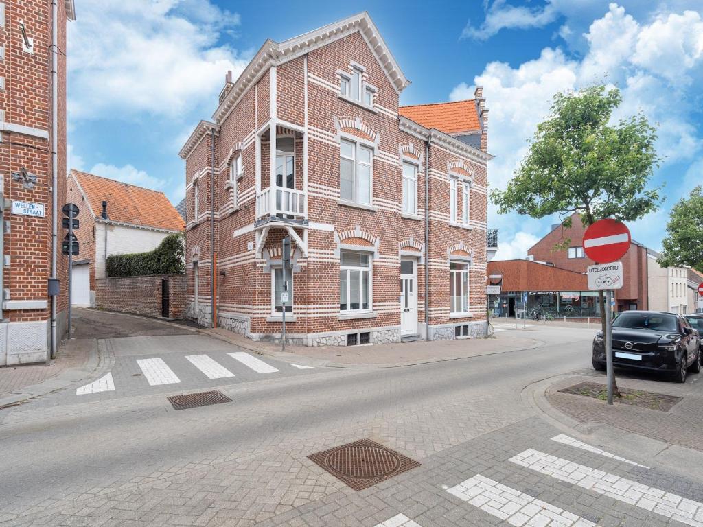 a red brick building on a street with a stop sign at Scenic villa in Borgloon with garden in Borgloon