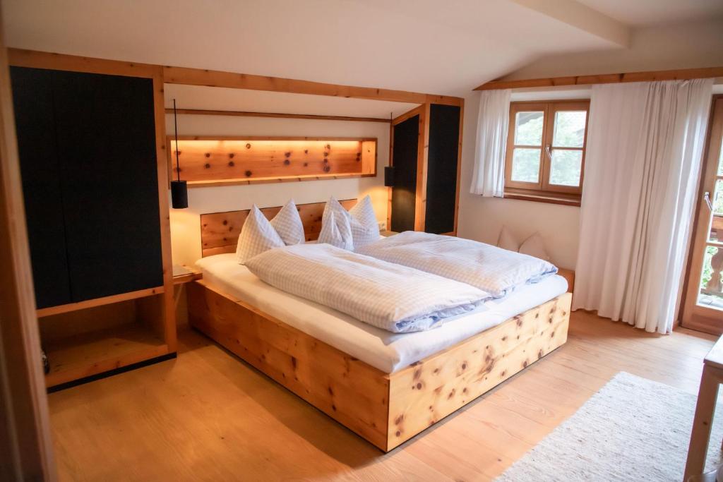 a bedroom with a large bed with a wooden headboard at Fannys in Weißach