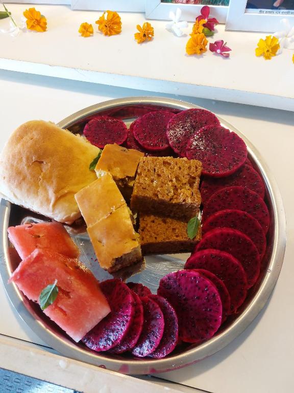 a plate of different types of food on a table at Ronika devi in Savu