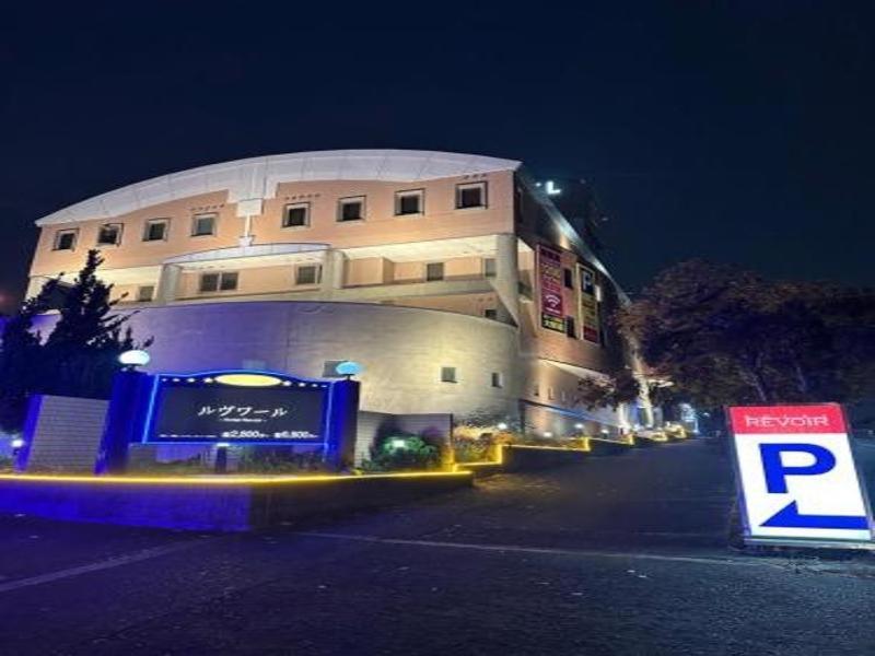 a building with a parking sign in front of it at Hotel Revoir in Izumi