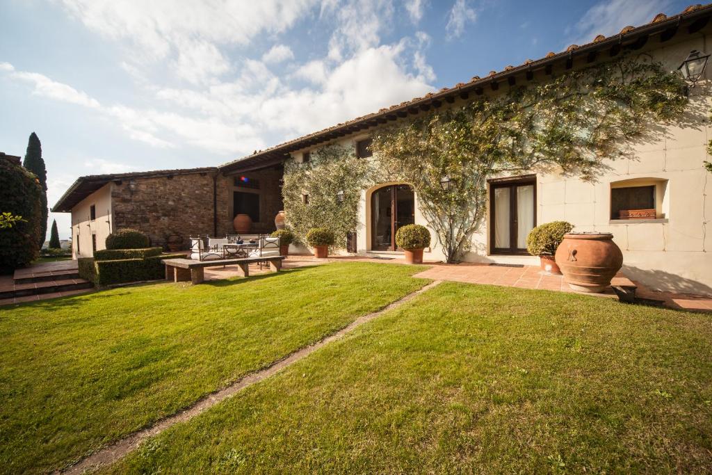 une maison avec une pelouse verte devant elle dans l'établissement Villa privata per famiglie o amici, à Barberino di Val dʼElsa