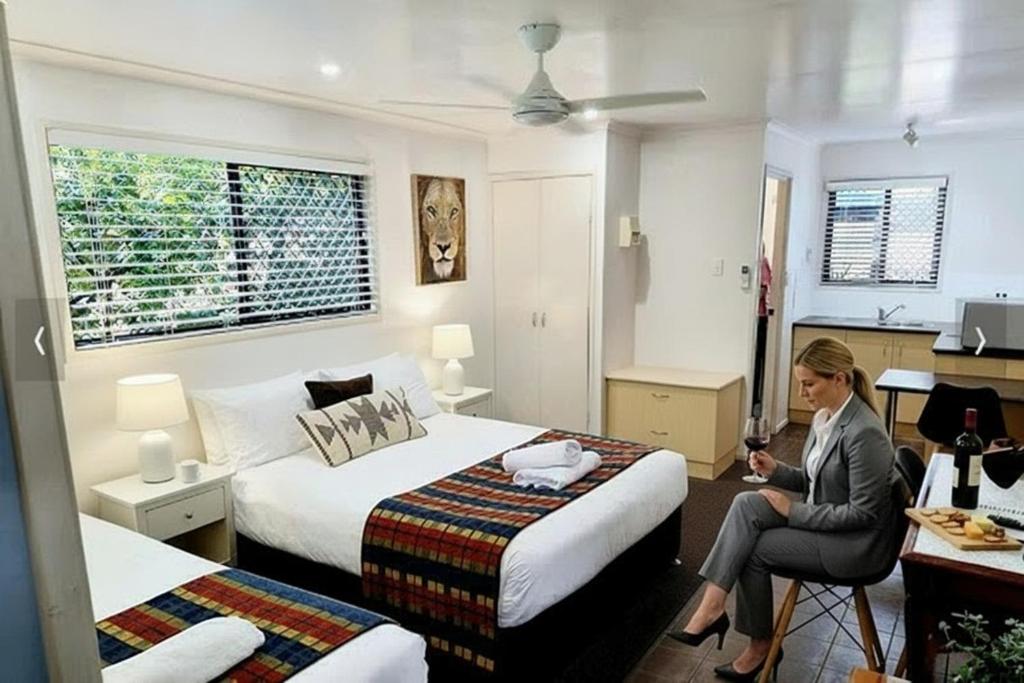a woman sitting in a chair in a hotel room at Central Studio Accommodation in Gladstone