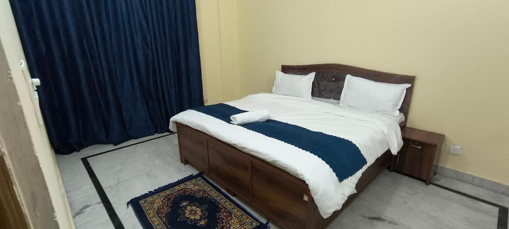 a bedroom with a bed with a blue and white blanket at Pb Legacy hotel in Noida