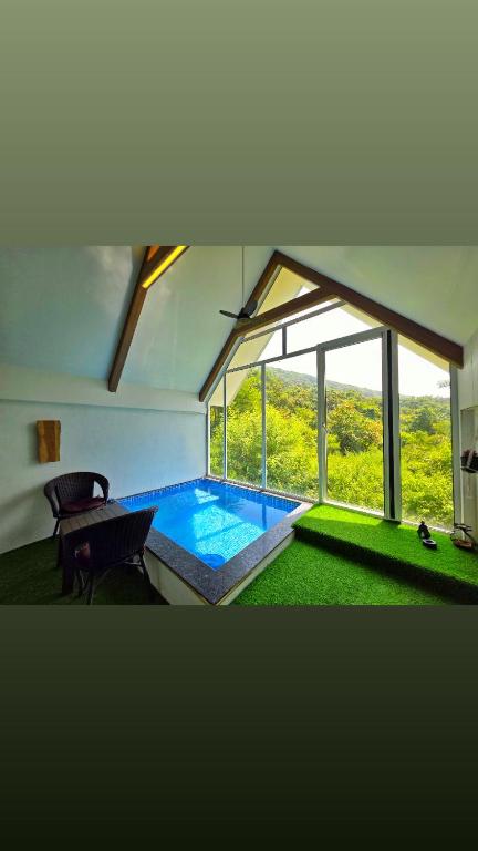 a swimming pool in a house with a large window at La Vida Villa in Bārsiv