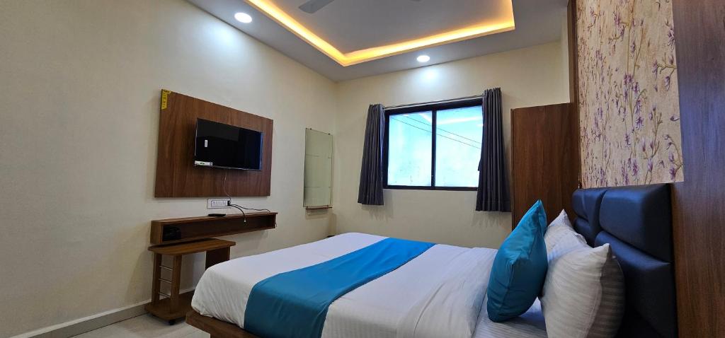 a hotel room with a bed and a television at Hotel Empire in Vapi