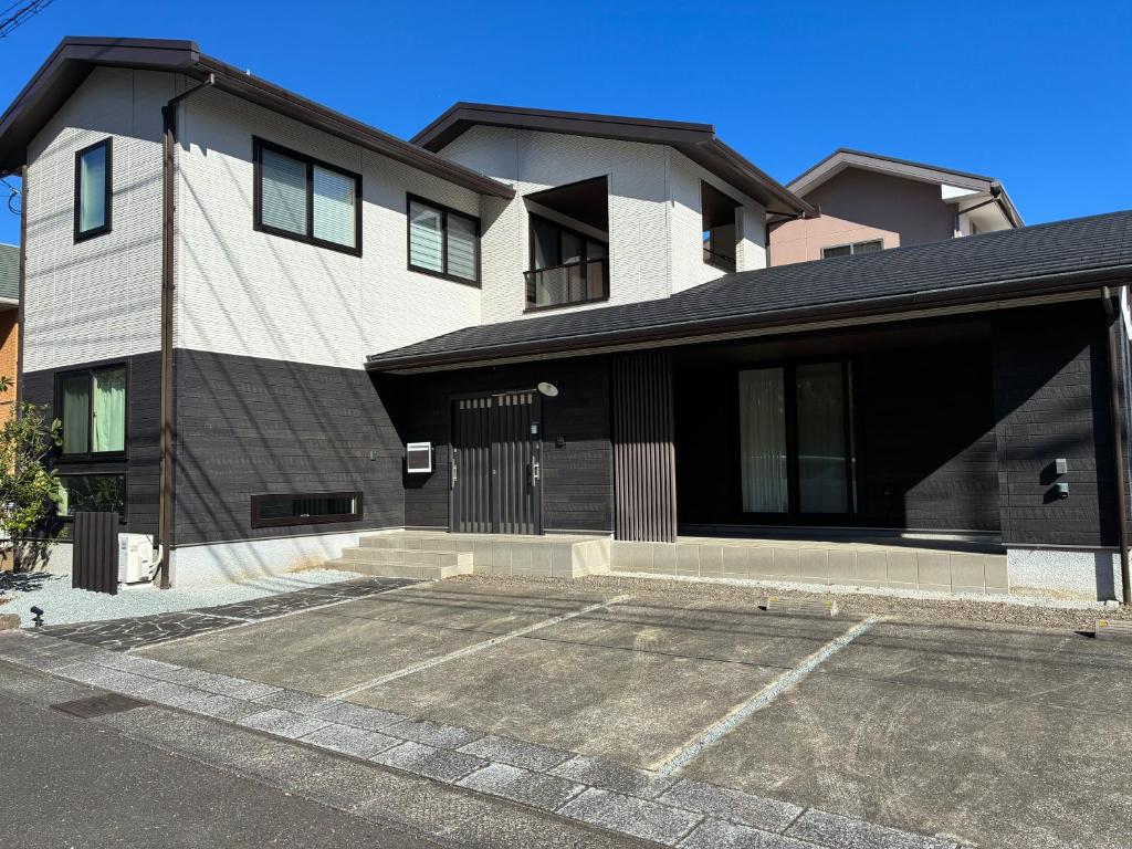 a white and black building with a parking lot at Aoshima Seaside Village in Miyazaki