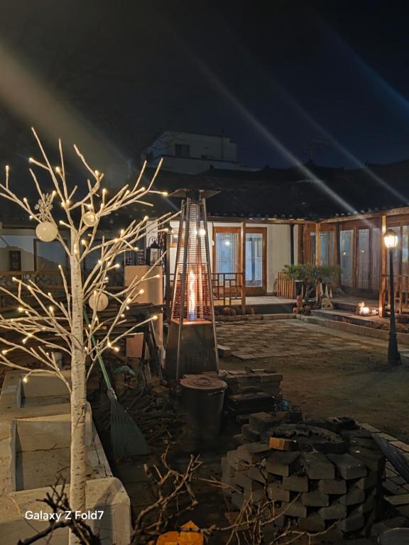 a tree and a slide in a yard at night at 서라벌옛집 in Gyeongju