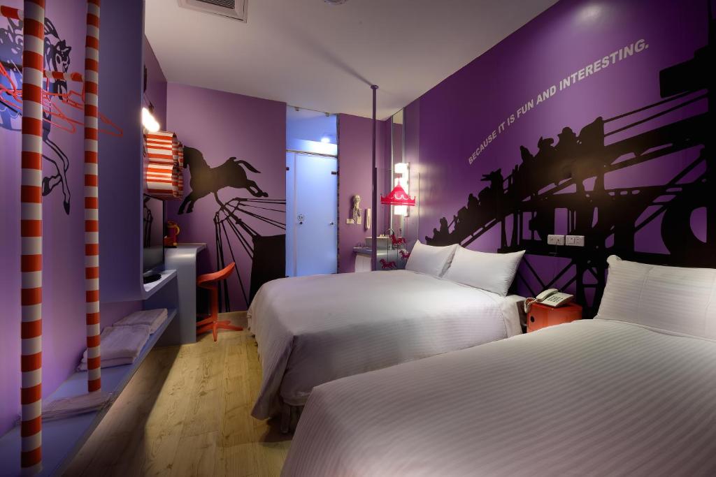 a bedroom with two beds and purple walls at NL Concept Hotel in Kaohsiung