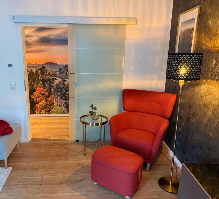 a living room with a chair and a table at Ferienwohnung Lucy - Moderne Ferienwohnung mit kostenlosem Parkplatz, Terrasse, nahe Bad Schandau und Malerweg in Bad Schandau