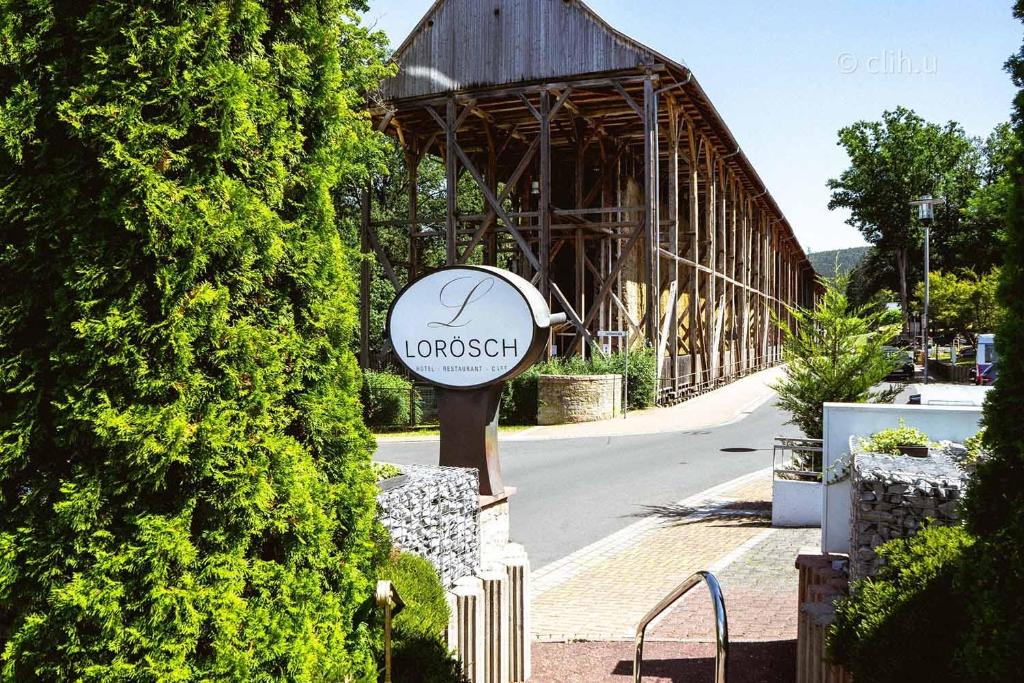 a sign in front of a building with a barn at Hotel Lorösch in Bad Orb